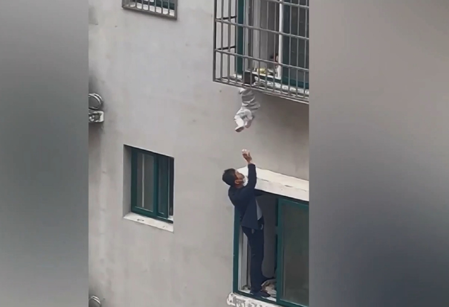Σοκάρει βίντεο από διάσωση παιδιού στην Κίνα που κρεμόταν από μπαλκόνι: Σφήνωσε το κεφάλι του στα κάγκελα